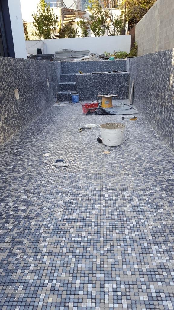 Pose de mosaïque dans une piscine en construction